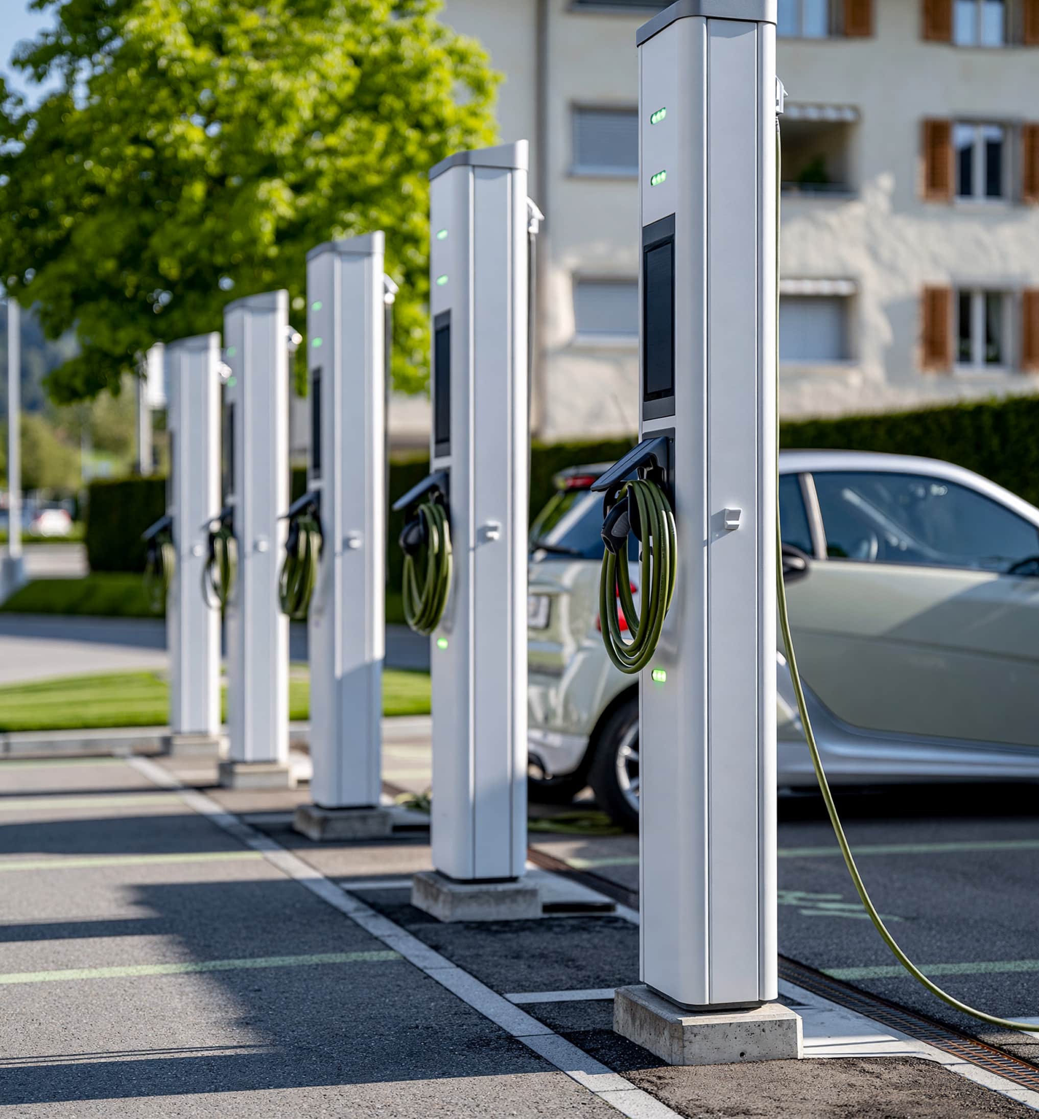 Reihe von Ladestationen für Elektroautos vor einem Bürogebäude
