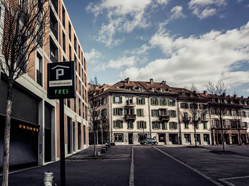 Einfahrt zum Parkhaus eines Einkaufscenters mit Anzeige «frei» an einer leeren Strasse